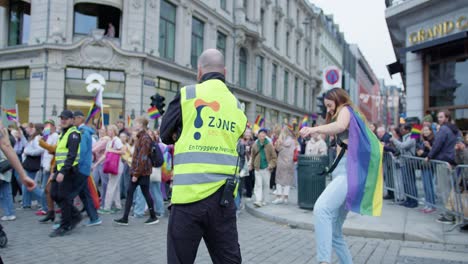 Two-happy-females-dancing-near-security-guard-in-Oslo-Pride-2022