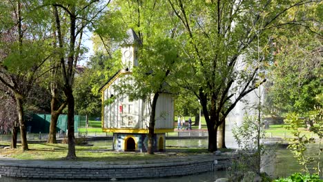 Miniature-chapel-near-waterspout-fountains-in-Doña-Casilda-Park,-Handheld-wide-shot