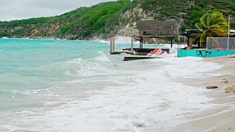 Wide-of-local-wooden-fishing-boat-being-smashed-into-pieces-during-sudden-storm-with-rough-waves,-Caribbean