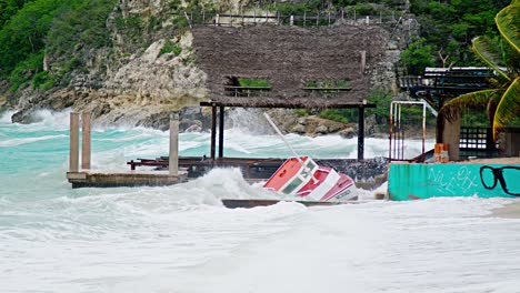 Barco-De-Pesca-Local-De-Madera-Siendo-Destrozado-En-Tierra-Durante-Una-Tormenta-Repentina-Con-Olas-ásperas,-Caribe