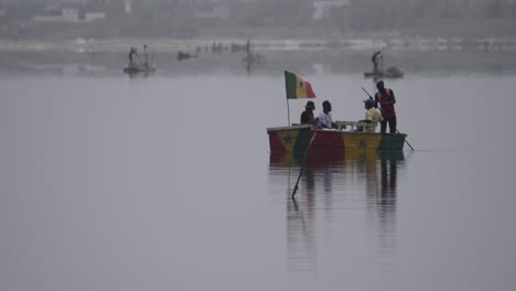 Three-black-tourists-sail-on-a-small-boat-pulled-by-a-man