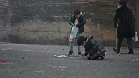 Group-of-children-playing-with-fireworks-and-firecrackers-in-the-street-of-Valencia-during-"Las-Fallas",-traditional-festival