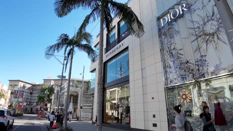 Pov-Pasando-Por-Las-Tiendas-De-Lujo-De-Dior-Y-Burberry-En-Rodeo-Drive,-Calle-Comercial-Próspera,-California