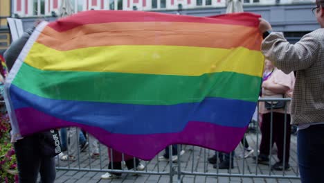 Young-girl-waving-rainbow-flag-in-Oslo-Pride-2022,-side-view