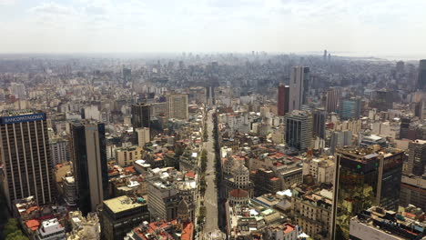 Sinking-aerial-of-downtown-Buenos-Aires,-avenue-and-famous-Obelisco