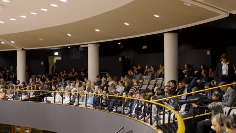 Visitors-sitting-in-the-European-Parliament-tribune-during-the-plenary-session-in-Brussels,-Belgium---panning-shot