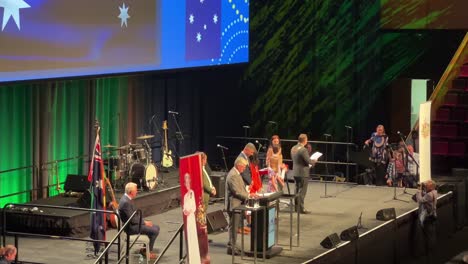 Gran-Ceremonia-De-Gran-Tamaño-En-Brisbane-Debido-A-Una-Pandemia,-Representantes-Seleccionados-Reciben-Su-Certificado-De-Ciudadanía-Del-Alcalde-Adrian-Schrinner-En-El-Escenario-Del-Centro-De-Convenciones-Y-Exposiciones