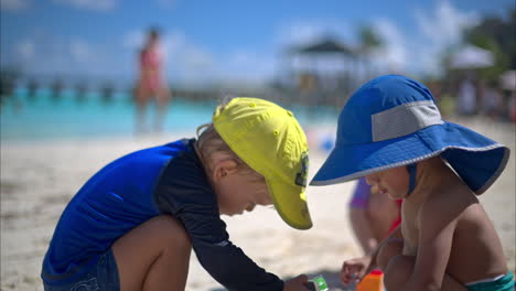 Close-up-of-three-young-babies-from-different-ethnicities-playing-at-the-beach-with-car-toys-on-a-hot-summer-day