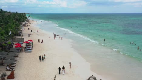 Turistas-En-La-Playa-Tropical-De-Arena-Blanca-En-La-Zona-Hotelera-De-Tulum-En-Un-Día-Soleado-De-Verano,-Antena