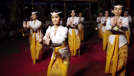 Girls-Dancing-at-Balinese-Temple,-Bali-Dance-from-Indonesia,-Religious-Ceremony-at-Hindu-Tradition,-wearing-White-and-Yellow-costumes,-Offer-for-Welcoming-the-Gods