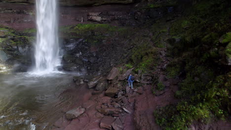 Antena-De-Hombre-Caminando-Sobre-Rocas-Hacia-Cascadas-En-Catskills,-Ny