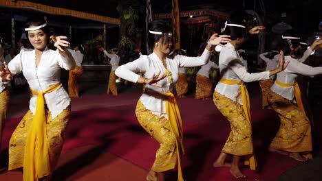 Grupo-De-Damas-Balinesas-Bailan-La-Ceremonia-Tradicional-Del-Templo-Hindú,-Bali-Indonesia-Por-La-Noche-En-Una-Celebración-Para-Los-Dioses-Vistiendo-Hermosos-Disfraces-Y-Maquillaje