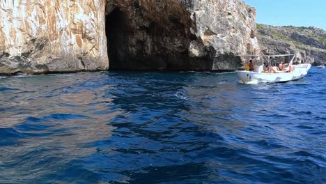 Personas-A-Bordo-De-Una-Lancha-Motora-Para-Un-Tour-En-Punta-Meliso,-Donde-Se-Encuentran-Los-Mares-Jónico-Y-Adriático