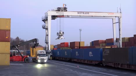 Camión-Volvo-Descargando-El-Contenedor-Amarillo-En-La-Terminal-De-Transporte-En-Senov-U-Ostravy-Con-Grúa-Metrans-Al-Atardecer