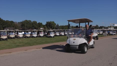 Golfer-In-Golfcarts-Vorbeifahren-Und-Winken