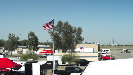 Cámara-Lenta-De-La-Bandera-Estadounidense-En-El-Pilar-De-Metal-Ondeando-En-El-Parque-De-Carreras-Buttonwillow