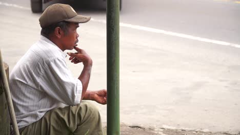 A-poor-man-is-sitting-on-the-side-of-road