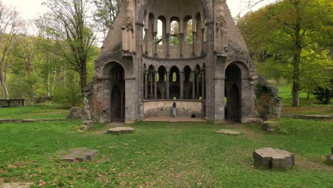 Pull-out-cinematic-drone-shot-of-a-middle-ages-Monastery-ruin-called-Heisterbach-Abbey-in-Siebengebirge,-Germany-during-autumn