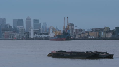 Ponton-Auf-Der-Themse-Mit-Schiff,-Gezeitensperre-Der-Themse-Und-Canary-Wharf,-Stadtbild