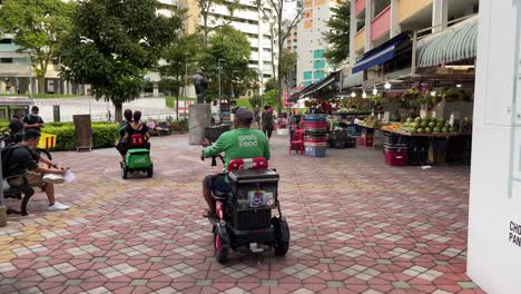 Agarrar-Alimentos-Jinetes-Montar-Sus-Ayudas-De-Movilidad-Personal-Para-La-Entrega-De-Alimentos-En-La-Ciudad-De-Chong-Pang,-Yishun,-Singapur