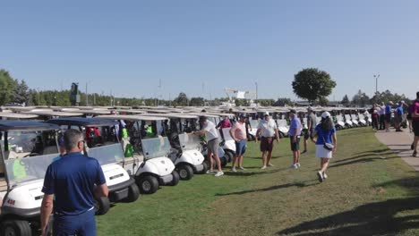 Larga-Fila-De-Carritos-De-Golf-Y-Gente-A-Su-Alrededor-A-Cámara-Lenta