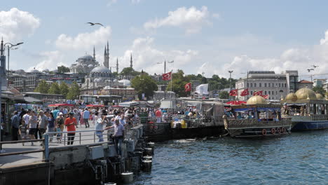 Gente-En-El-Paseo-Marítimo-Del-Bósforo-Con-La-Mezquita-Süleymaniye-En-El-Fondo,-Paisaje-Urbano-De-Estambul