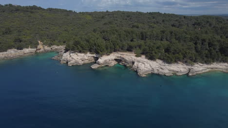 Toma-De-Un-Dron-De-Una-Costa-Acantilada-En-Croacia---El-Dron-Muestra-Agua-Clara-De-Kristall-Y-Una-Bahía-Rocosa