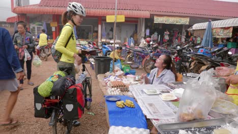 Mujer-Asiática-Deportiva-Comprando-Comida-En-Un-Puesto-Callejero-De-Mercado-En-Laos,-Sudeste-De-Asia