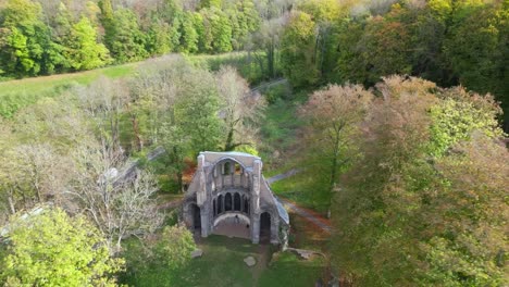 High-angle-cinematic-drone-shot-of-a-middle-ages-Monastery-ruin-called-Heisterbach-Abbey-in-Siebengebirge,-Germany-during-autumn