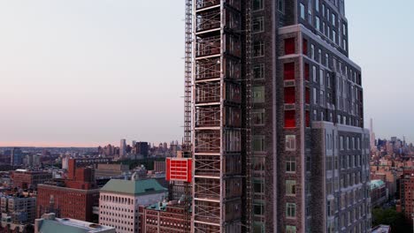 Vista-Aérea-Alrededor-Del-Ascensor-De-Construcción-En-El-Lado-De-La-Sala-De-Claremont,-Puesta-De-Sol-En-Nueva-York,-EE.UU.---Dando-Vueltas,-Disparo-De-Drones