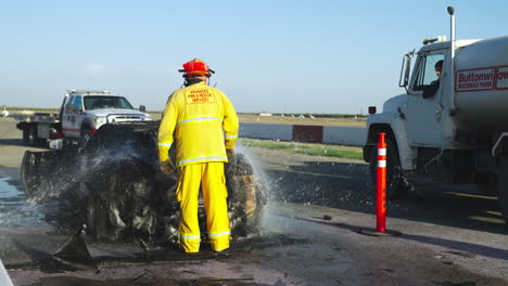 Fireman-extinguishing-and-examining-the-burned-sports-car