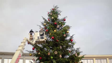 Kran-Mit-Zwei-Arbeitern,-Die-Sich-Für-Dekorationsarbeiten-In-Der-Nähe-Des-Weihnachtsbaums-Erheben