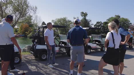 Golfer-Draußen,-Die-In-Einer-Menge-Herumstehen-Und-An-Ihren-Golfcarts-Warten