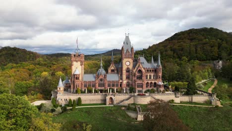 Toma-De-Salida-Del-Frente-Del-Castillo-De-Drachenburg-Situado-En-Drachenfels,-Königswinter,-Alemania-Con-Un-Hermoso-Sol-Otoñal-Y-Hojas-De-Colores