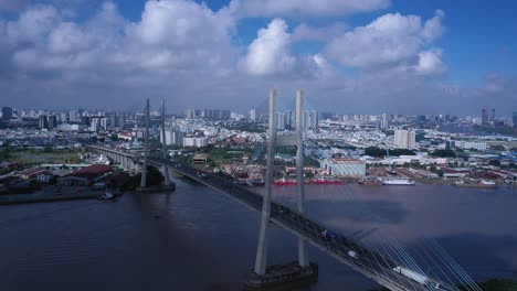 Aerial-view-of-Phu-My-Bridge-over-Saigon-river-with-road-and-river-transportation-on-a-sunny-day