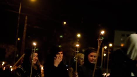 Personas-Que-Van-En-Una-Procesión-Patriótica-De-Antorchas-En-La-Ciudad-De-Liepaja-El-Día-De-Lacplesa,-Tarde-De-Otoño,-Paisaje-De-La-Ciudad,-Semáforos,-Plano-Medio