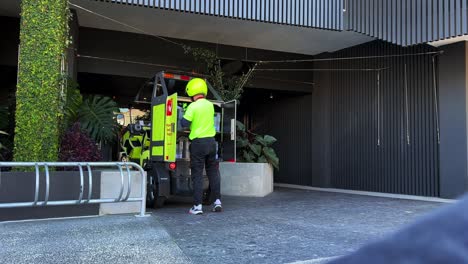 Cartero-De-Correos-De-Australia-Conduciendo-Un-Vehículo-Eléctrico-Que-Funciona-Con-Baterías-En-La-Carretera-Entregando-Paquetes-A-Domicilio,-Transformación-Tecnológica,-Reducción-Del-Impacto-Ambiental-Y-Lucha-Contra-El-Cambio-Climático