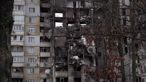 Äste-Wiegen-Sich-Im-Wind-Vor-Einem-Zerstörten-Hochhaus-In-Der-Saltivka-Siedlung,-Das-Bei-Heftigen-Kämpfen-Schwer-Beschädigt-Wurde,-Als-Russische-Invasoren-Versuchten,-Die-Stadt-Zu-Besetzen