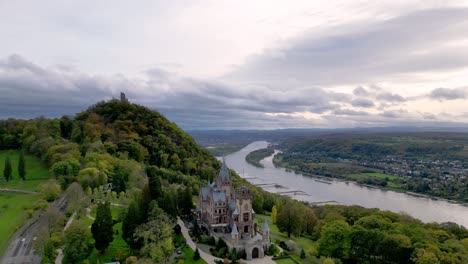 Toma-De-Salida-Del-Castillo-De-Drachenburg-Situado-En-Drachenfels,-Königswinter,-Alemania,-Con-Un-Hermoso-Cielo-Otoñal-Y-El-Río-Rhein-Al-Fondo