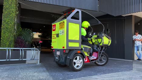 Australien-Postpostbote-Fährt-Batteriebetriebenes-Elektrofahrzeug-Auf-Der-Straße-Und-Liefert-Pakete-An-Die-Tür,-Technologischer-Umbau-Und-Umweltfreundlich-Mit-Reduzierung-Der-Kohlenstoffemissionen