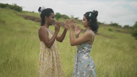 Wide-angle-on-Two-girls-playing-a-hand-clapping-game-in-a-countryside