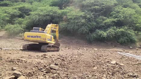 Excavator-during-earthmoving-work-at-open-pit-mining-on-sunset-background