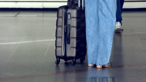 the-lower-legs-of-waiting-passengers-and-their-luggage-trolleys-at-brasilia-airport