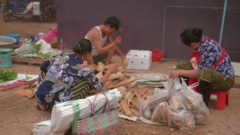 Lokale-Asiaten-Sitzen-Auf-Dem-Boden-Und-Schneiden-Holz-Für-Den-Verkauf-Auf-Der-Straße