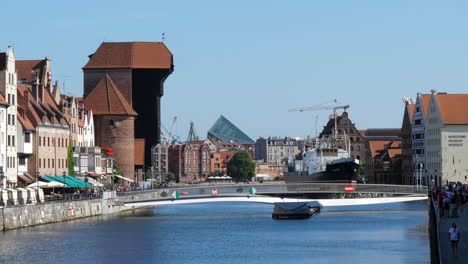 Grúa-Portuaria-Histórica-Y-Puente-Moviéndose-En-Posición-Sobre-El-Río-Motława-En-Gdansk,-Polonia