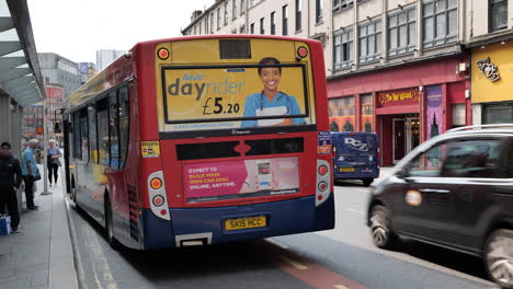 Alexander-Dennis-Enviro300-bus-wating-for-incoming-passengers-at-a-bus-stop-in-Glasgow