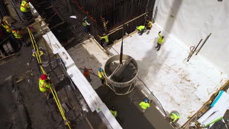 Aerial-view-around-workers-cementing-the-foundation,-at-a-construction-site-in-NYC---orbit,-drone-shot