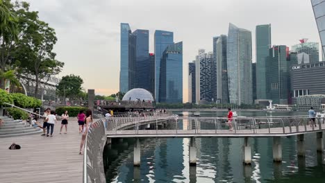 La-Gente-Camina-Fuera-De-La-Tienda-Minorista-Frente-Al-Mar-De-Louis-Vuitton-Y-Contra-El-Horizonte-Moderno-De-Marina-Bay,-Singapur