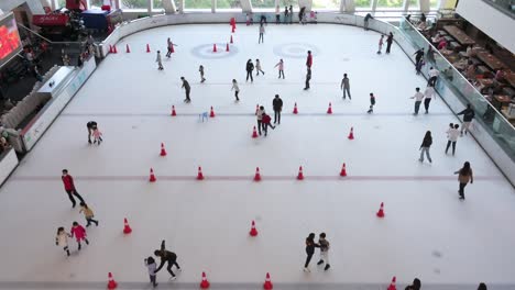 Una-Vista-Amplia-De-Participantes-Chinos-De-Todas-Las-Edades-Vistos-Disfrutando-Y-Aprendiendo-Patinaje-Sobre-Hielo-En-Interiores-En-Un-Centro-Comercial-En-Hong-Kong