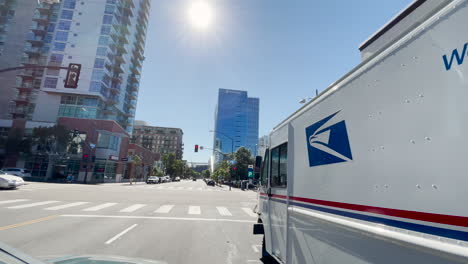 Conduciendo-Por-Un-Camión-De-Reparto-Usps-Estacionado-Al-Costado-De-La-Carretera-En-El-Centro-De-San-Diego,-California